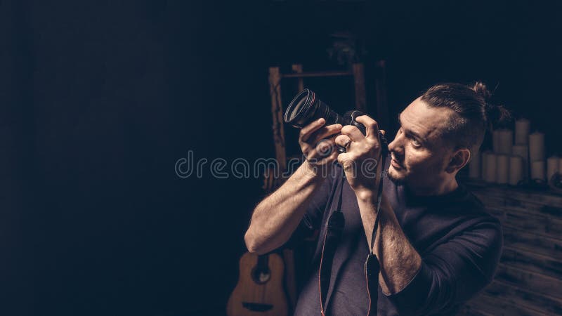 Il fotografo sta tenendo la macchina fotografica in sue mani che prendono la sorveglianza di scopo fotografie stock Il fotografo sta tenendo la macchina fotografica in sue mani che prendono la sorveglianza di scopo fotografie stock
