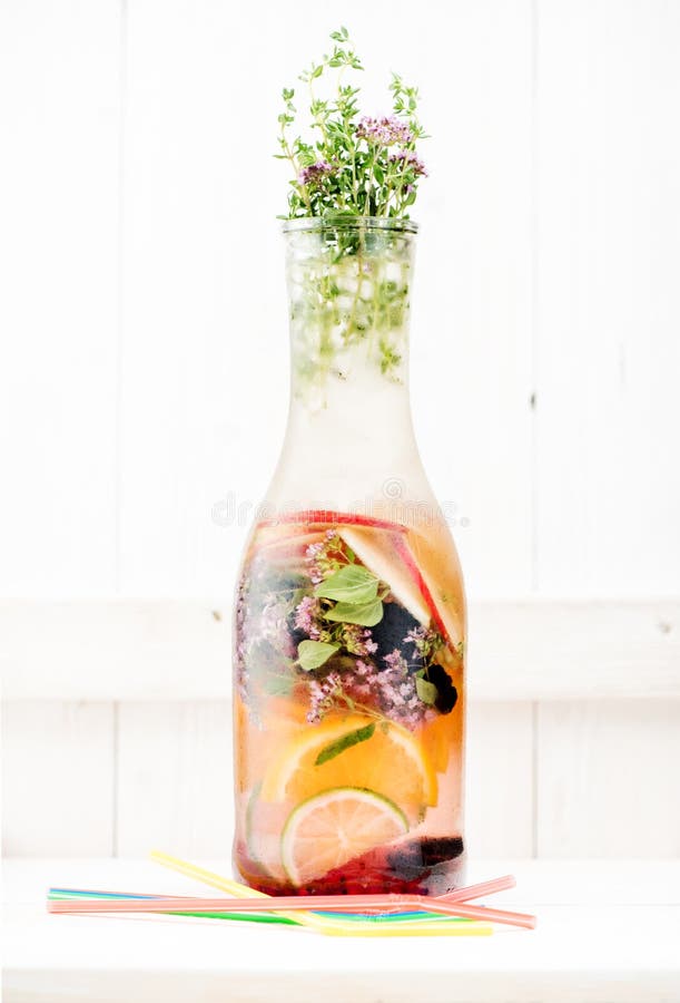 Il freddo ha infuso la limonata dell'estate dell'acqua della disintossicazione con le bacche, le erbe ed i frutti in una bottigli immagine stock libera da diritti Il freddo ha infuso la limonata dell'estate dell'acqua della disintossicazione con le bacche, le erbe ed i frutti in una bottigli immagine stock libera da diritti
