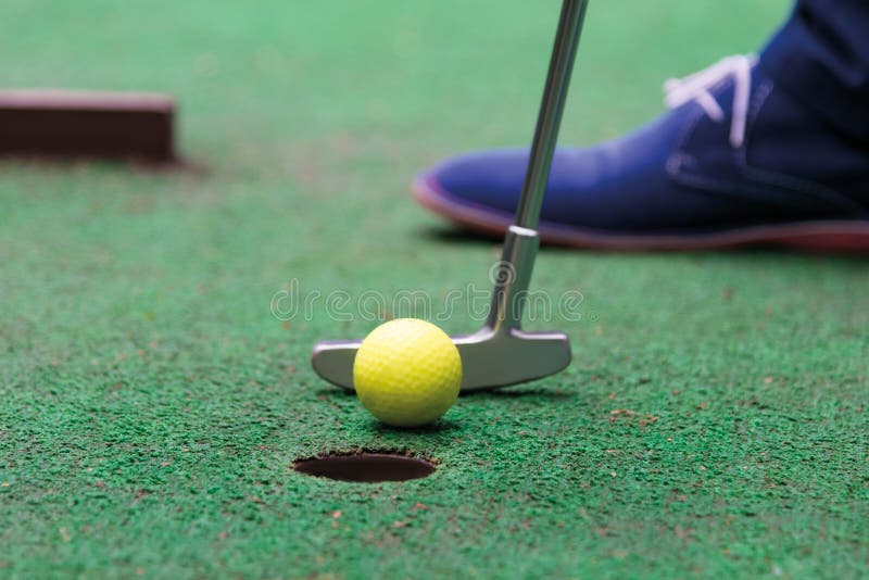 Player makes a decisive blow in the game of mini golf. Player makes a decisive blow in the game of mini golf