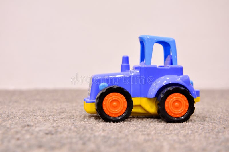 Il giocattolo dei bambini, trattore blu fotografia stock Il giocattolo dei bambini, trattore blu fotografia stock