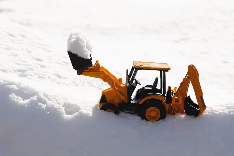 Tractor toy removes snow out, close-up view. Tractor toy removes snow out, close-up view