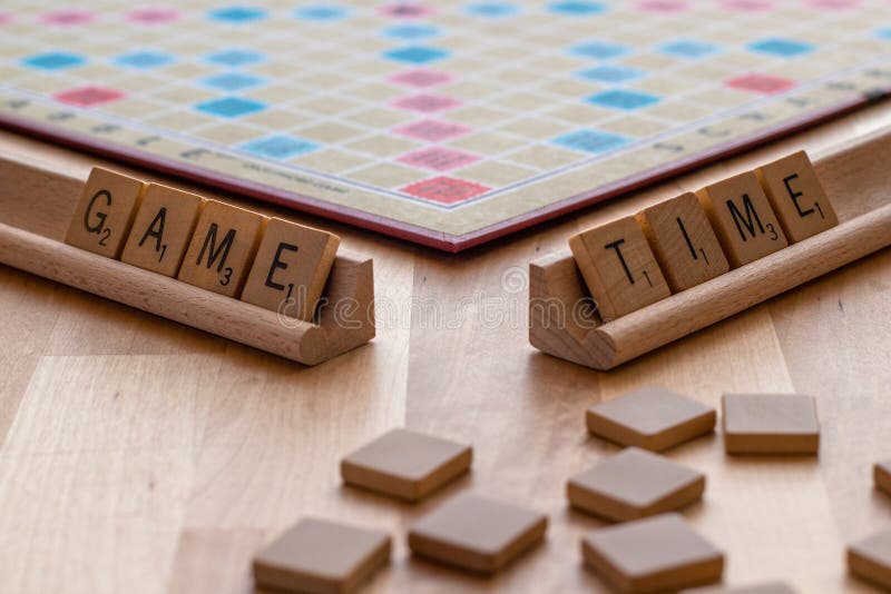 Il gioco da tavolo dello Scarabeo con fruga il periodo “tempo delle mattonelle del gioco “ immagine stock Il gioco da tavolo dello Scarabeo con fruga il periodo “tempo delle mattonelle del gioco “ immagine stock