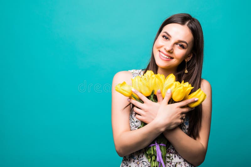 Il giorno delle donne di tempo di primavera ritratto della donna sorridente con il mazzo dei tulipani gialli in mani isolate su f fotografia stock