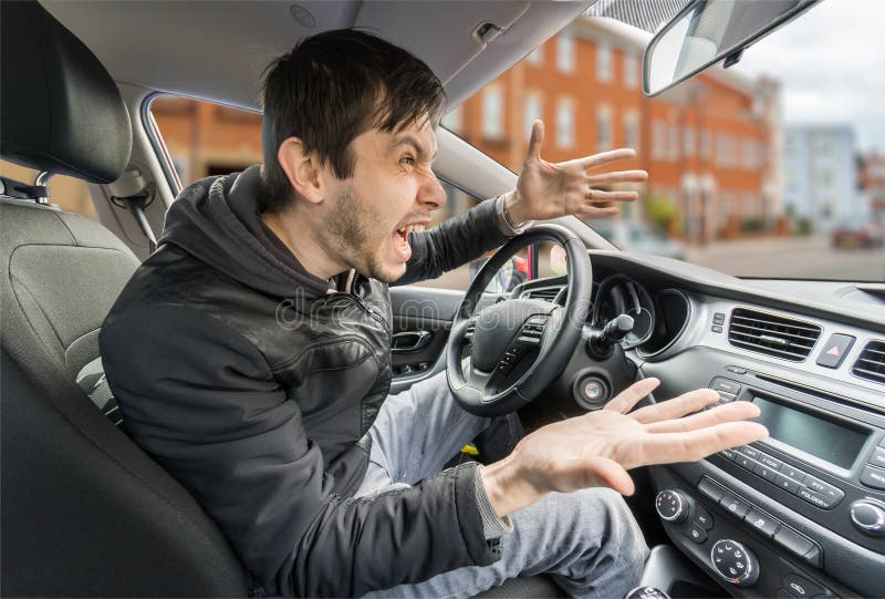 Il giovane autista arrabbiato sta determinando un'automobile e gridare immagine stock libera da diritti