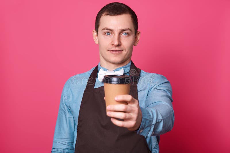 Il giovane barista maschio bello vi suggerisce tazza di caffè fatta lui, dalla camicia blu elegante vestita, dalla cravatta a far fotografie stock libere da diritti Il giovane barista maschio bello vi suggerisce tazza di caffè fatta lui, dalla camicia blu elegante vestita, dalla cravatta a far fotografie stock libere da diritti