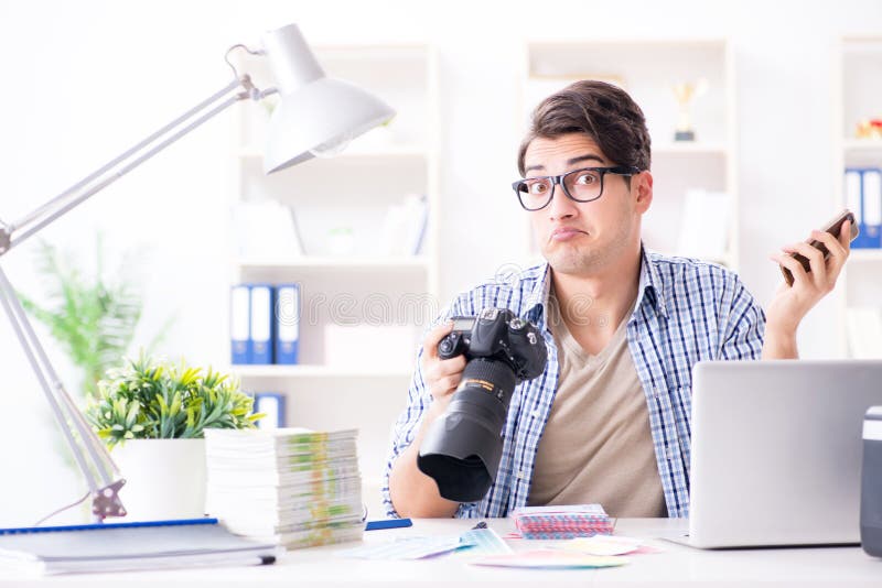 Il giovane fotografo che lavora con la sua macchina fotografica immagini stock libere da diritti Il giovane fotografo che lavora con la sua macchina fotografica immagini stock libere da diritti