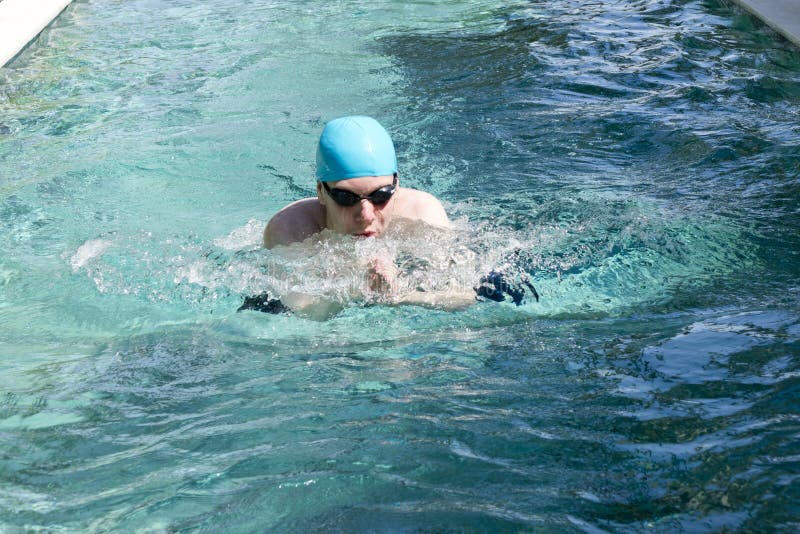 Il giovane nuota in stile sportivo fotografia stock