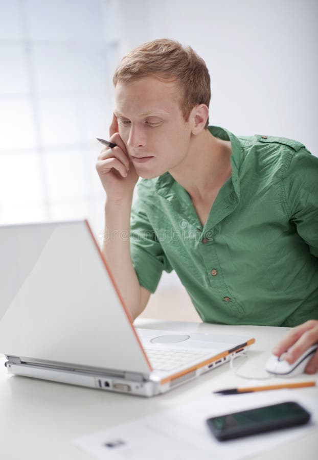 Un giovane sta lavorando al computer immagini stock libere da diritti