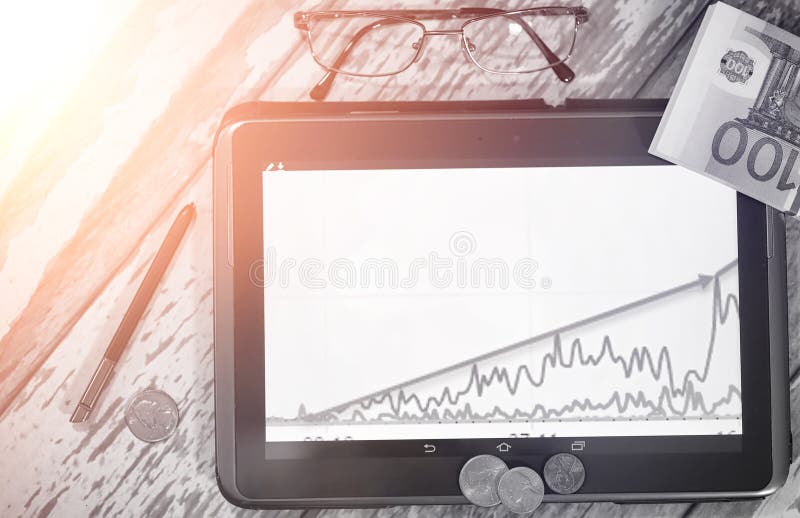 Il grafico di crescita di reddito Compressa elettronica con un grafico del gr immagine stock libera da diritti Il grafico di crescita di reddito Compressa elettronica con un grafico del gr immagine stock libera da diritti