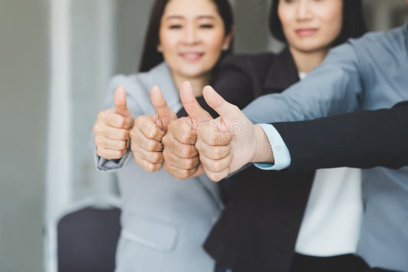 Il gruppo dell'unire di affari forza il lavoro e la mostra dei pollici su come si immagine stock Il gruppo dell'unire di affari forza il lavoro e la mostra dei pollici su come si immagine stock