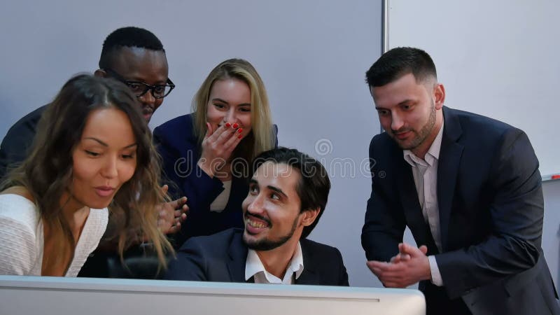 Il gruppo di business multirazziale ha scosso con successo, sorpreso, sorridente e ha guardato il computer portatile