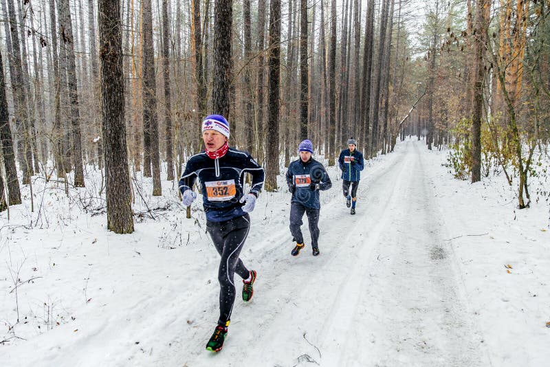 il gruppo di corridori maschii che eseguono la foresta nevosa, neve cade fotografia stock libera da diritti il gruppo di corridori maschii che eseguono la foresta nevosa, neve cade fotografia stock libera da diritti
