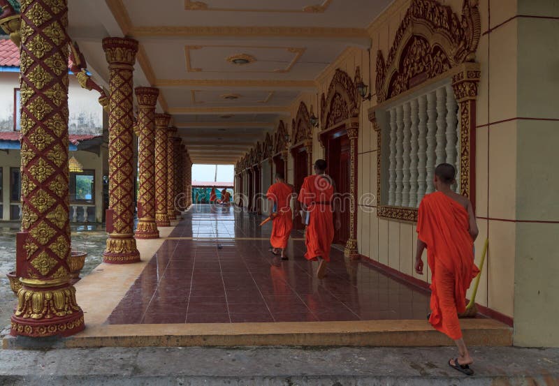 Il gruppo di giovani monaci buddisti asiatici sudorientali cammina lungo il corridoio in Wat Krom in Sihonoukville, Cambogia fotografia stock Il gruppo di giovani monaci buddisti asiatici sudorientali cammina lungo il corridoio in Wat Krom in Sihonoukville, Cambogia fotografia stock