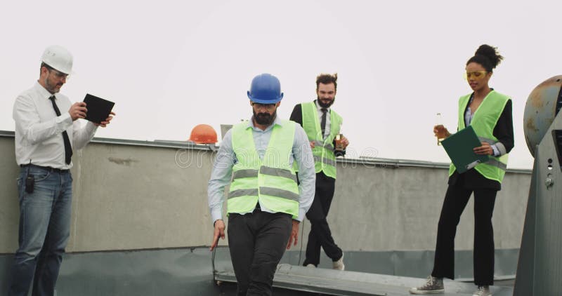 Il gruppo di lavoratori multietnici al cantiere fa ballare dell'ingegnere di tempo uno della rottura giovane eccitare indossando video d archivio Il gruppo di lavoratori multietnici al cantiere fa ballare dell'ingegnere di tempo uno della rottura giovane eccitare indossando video d archivio