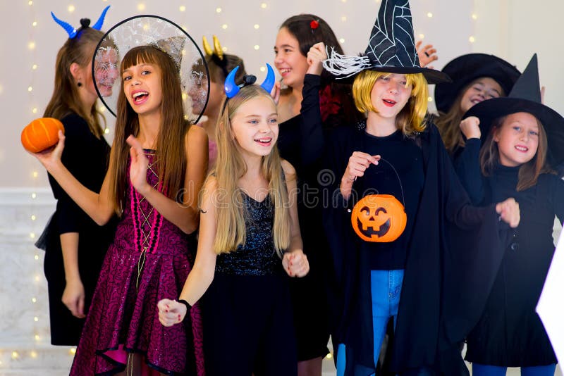 Il gruppo felice di adolescenti balla in costumi di Halloween fotografie stock libere da diritti Il gruppo felice di adolescenti balla in costumi di Halloween fotografie stock libere da diritti