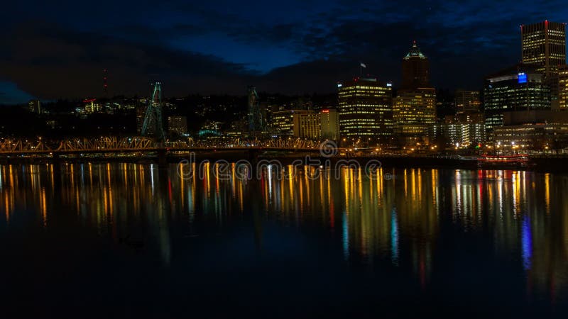 Il lasso di tempo di muoversi si rannuvola l'orizzonte del centro della città di Portland Oregon con la riflessione dell'acqua e