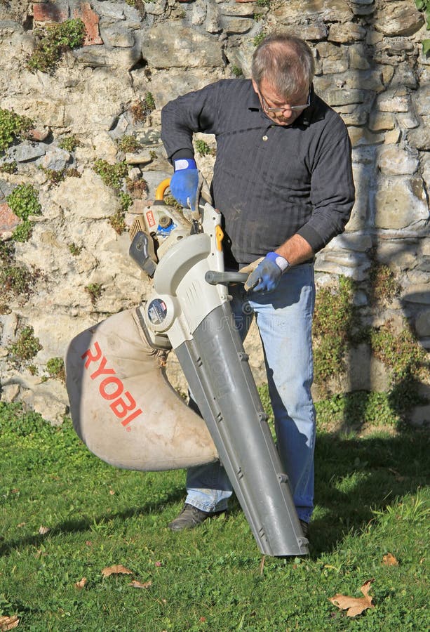 Il lavoratore manuale all'aperto pulisce le foglie cadute fotografia stock libera da diritti Il lavoratore manuale all'aperto pulisce le foglie cadute fotografia stock libera da diritti