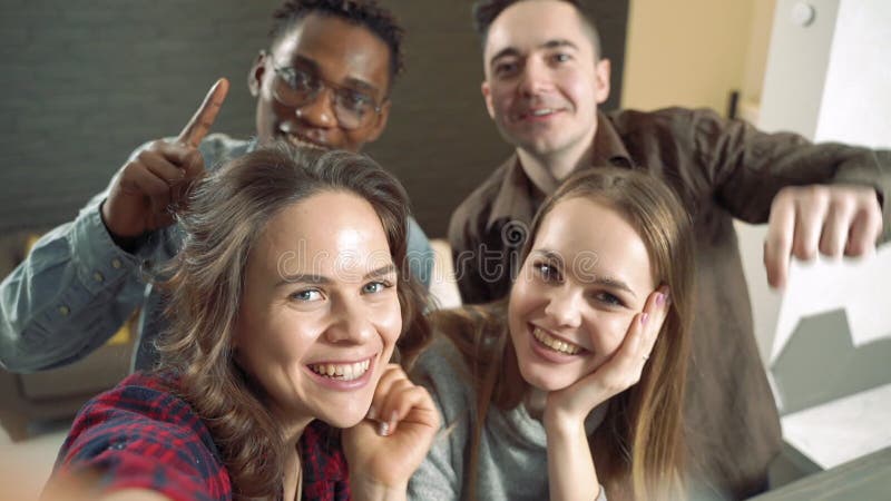 Il lento movimento di gruppi di giovani amici di diverse etnie si stanno divertendo e si stanno facendo un selfie insieme