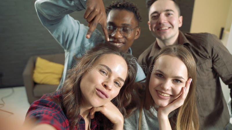 Il lento movimento di gruppi di giovani amici di diverse etnie si stanno divertendo e si stanno facendo un selfie insieme