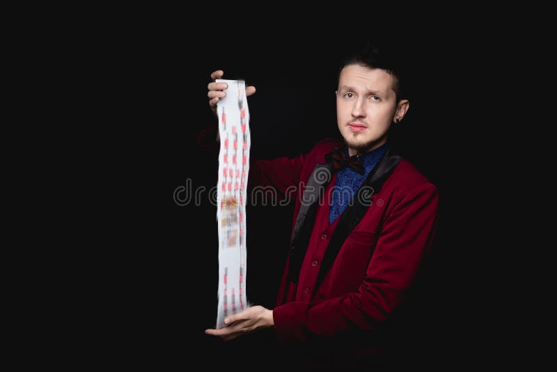 Il mago mostra la messa a fuoco con le carte da gioco sullo sfondo nero immagini stock libere da diritti