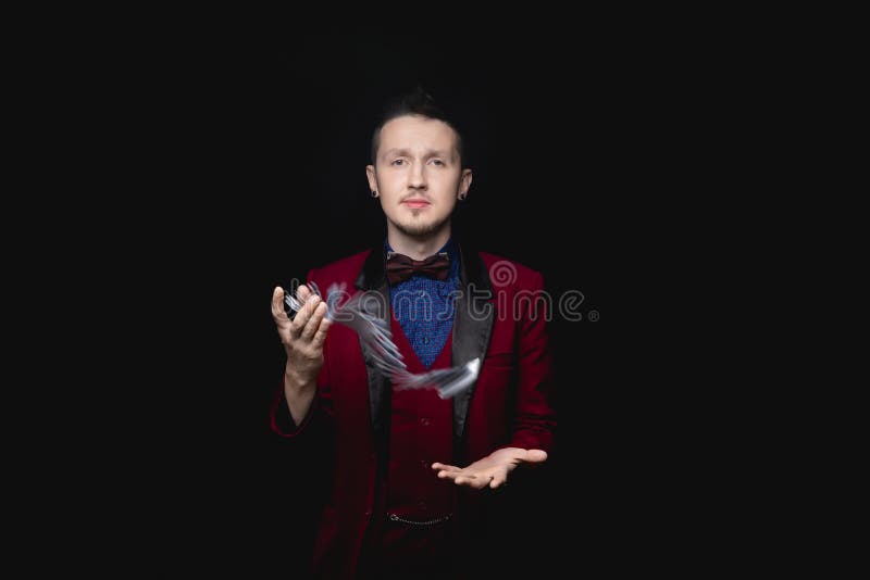 Il mago mostra la messa a fuoco con le carte da gioco sullo sfondo nero fotografia stock