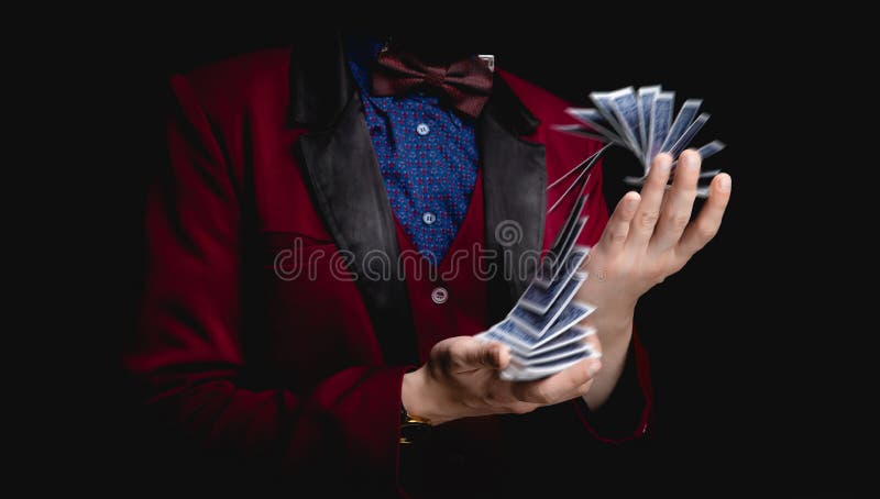 Il mago mostra trucco con carte da gioco su sfondo scuro, stand-up concettuale fotografia stock