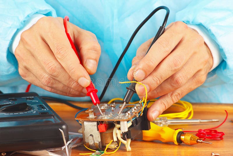 Il Master misura i parametri dell'apparecchio elettronico con il multimetro fotografia stock libera da diritti