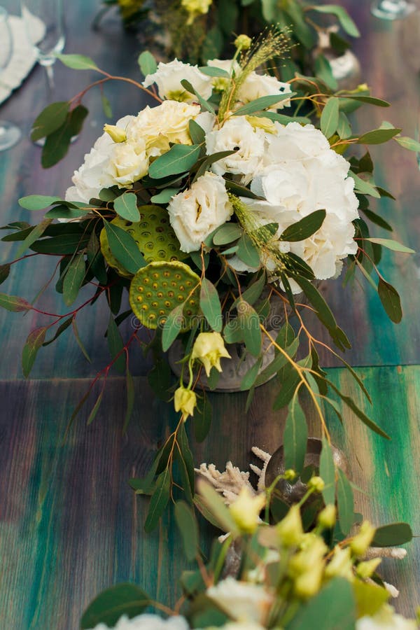 Il mazzo dei fiori e della pianta è sulla tavola di nozze immagini stock Il mazzo dei fiori e della pianta è sulla tavola di nozze immagini stock