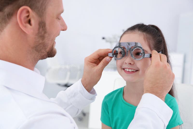 Il medico dei bambini che mette struttura di prova sulla bambina nella clinica immagini stock libere da diritti Il medico dei bambini che mette struttura di prova sulla bambina nella clinica immagini stock libere da diritti