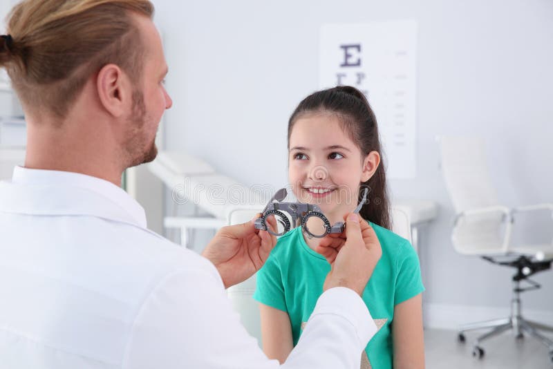 Il medico dei bambini che mette struttura di prova sulla bambina nella clinica immagini stock libere da diritti Il medico dei bambini che mette struttura di prova sulla bambina nella clinica immagini stock libere da diritti