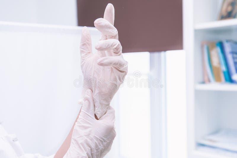 A medical professional, doctor or nurse puts on or removes sterile disposable gloves horizontal photo. A medical professional, doctor or nurse puts on or removes sterile disposable gloves horizontal photo