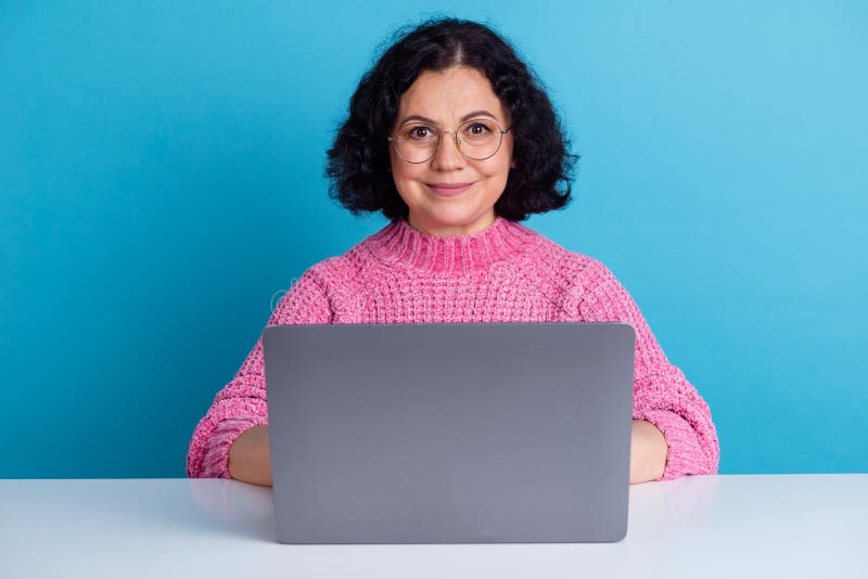 Il mercato femminile maturo lavora su netbook isolato su sfondo blu immagini stock libere da diritti