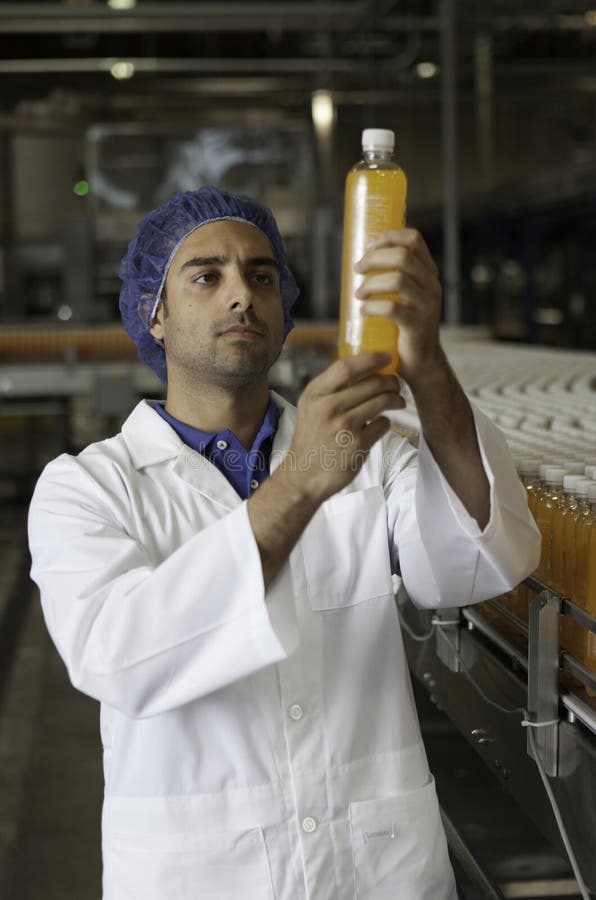 Il metà di esame adulto del lavoratore dell'industria imbottiglia la fabbrica fotografie stock Il metà di esame adulto del lavoratore dell'industria imbottiglia la fabbrica fotografie stock