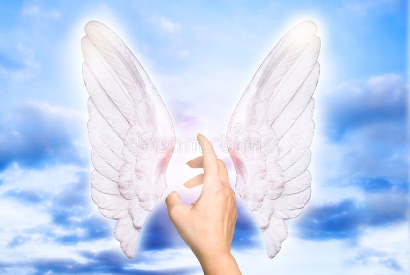 A female hand touching divine light of angel wings like a concept for angel love, guardian angels and angel protection. A female hand touching divine light of angel wings like a concept for angel love, guardian angels and angel protection