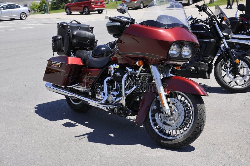 Il motociclo rosso di Harley Davidson ha parcheggiato in Rockport dalla provincia di Ontario nel Canada immagini stock Il motociclo rosso di Harley Davidson ha parcheggiato in Rockport dalla provincia di Ontario nel Canada immagini stock
