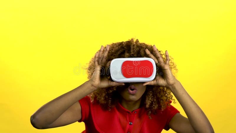 Il mulatto in vetri di realtà virtuale sta guardando un video interessante Fondo giallo Movimento lento