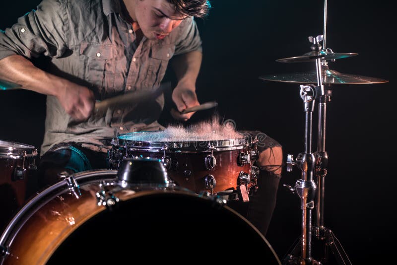 Il musicista che gioca i tamburi con spruzza, fondo nero con bella luce morbida fotografie stock libere da diritti Il musicista che gioca i tamburi con spruzza, fondo nero con bella luce morbida fotografie stock libere da diritti