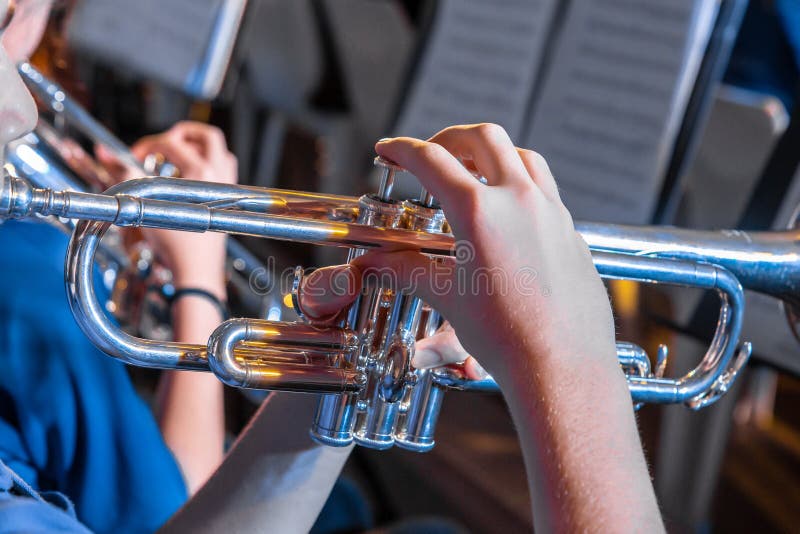 Il musicista maschio passa la tenuta e tromba del gioco in un concerto della banda immagini stock Il musicista maschio passa la tenuta e tromba del gioco in un concerto della banda immagini stock