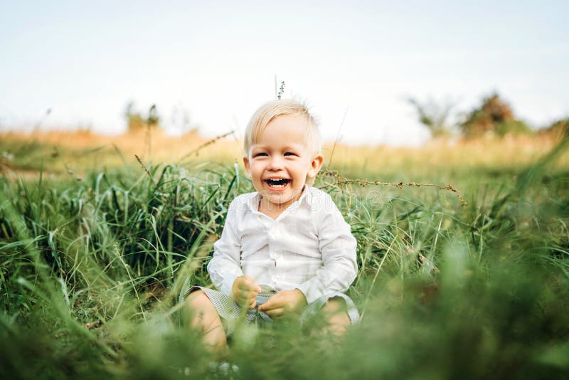 Il neonato abbastanza piccolo si diverte all'aperto immagini stock libere da diritti Il neonato abbastanza piccolo si diverte all'aperto immagini stock libere da diritti