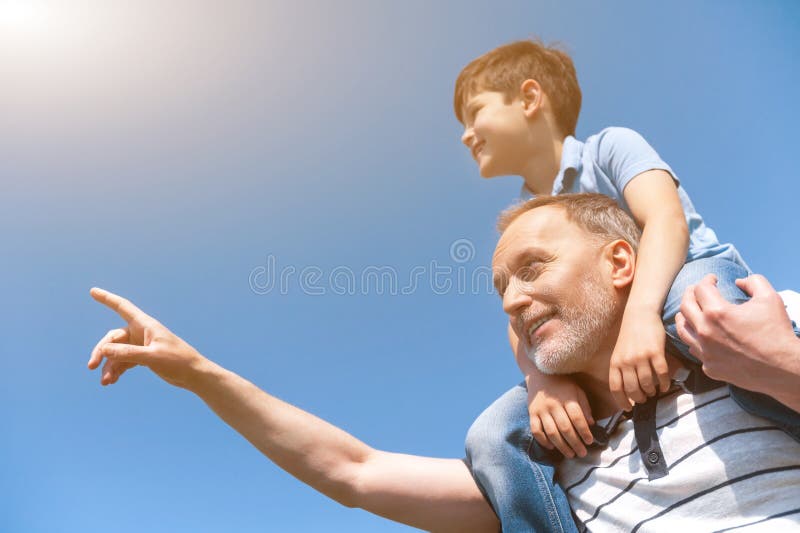 Il nonno maturo allegro sta insegnando al suo nipote fotografie stock