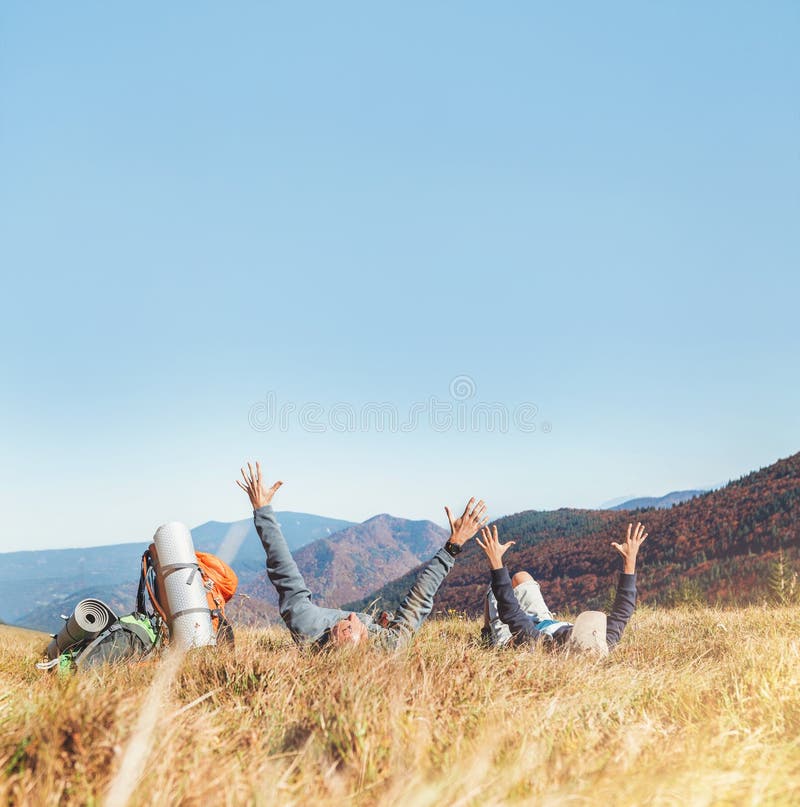 Il padre e le viandanti di viaggiatori con zaino e sacco a pelo dell'AON si trovano con le mani su fotografie stock libere da diritti Il padre e le viandanti di viaggiatori con zaino e sacco a pelo dell'AON si trovano con le mani su fotografie stock libere da diritti