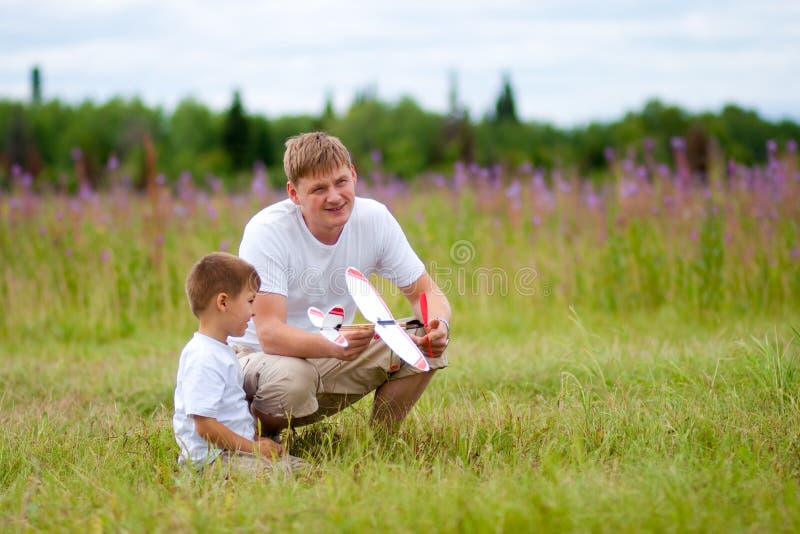 Il padre ed il figlio lanciano il modello piano in estate fotografia stock Il padre ed il figlio lanciano il modello piano in estate fotografia stock