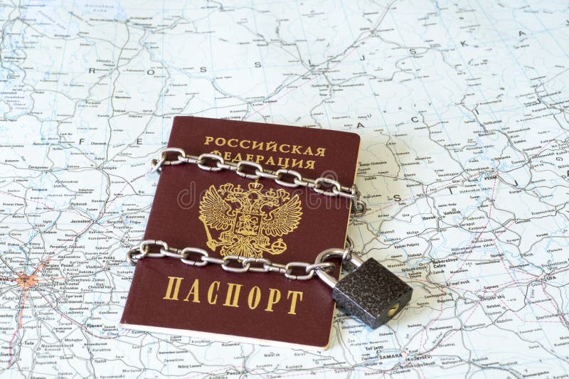 Il passaporto di un cittadino della Federazione Russa in una catena del metallo sul fissa i precedenti della mappa geografica del immagine stock libera da diritti Il passaporto di un cittadino della Federazione Russa in una catena del metallo sul fissa i precedenti della mappa geografica del immagine stock libera da diritti