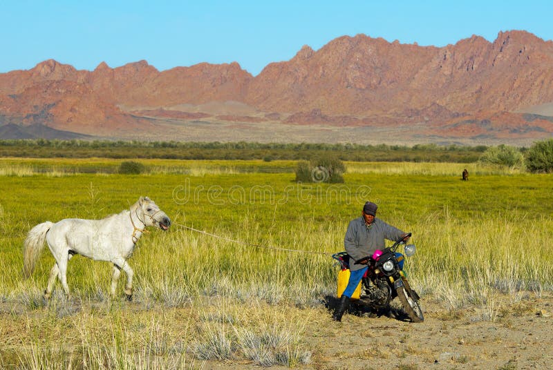 Il pastore mongolo non identificato guida la motocicletta immagini stock Il pastore mongolo non identificato guida la motocicletta immagini stock