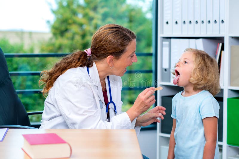 Il pediatra femminile in cappotto bianco del laboratorio ha esaminato il piccolo paziente immagini stock libere da diritti Il pediatra femminile in cappotto bianco del laboratorio ha esaminato il piccolo paziente immagini stock libere da diritti