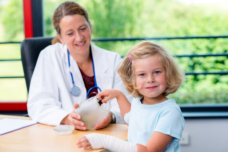 Il pediatra femminile ha candys per una bambina fotografia stock Il pediatra femminile ha candys per una bambina fotografia stock