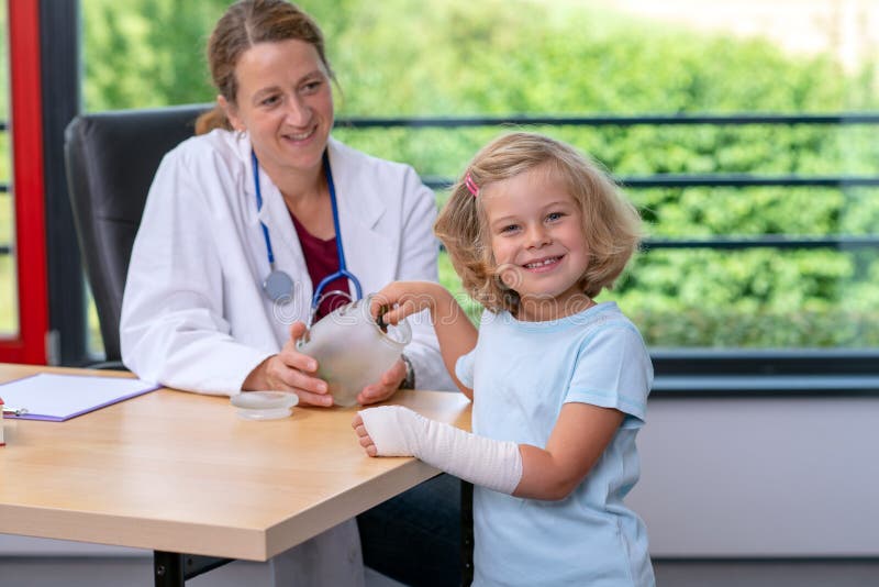 Il pediatra femminile ha candys per una bambina fotografia stock Il pediatra femminile ha candys per una bambina fotografia stock