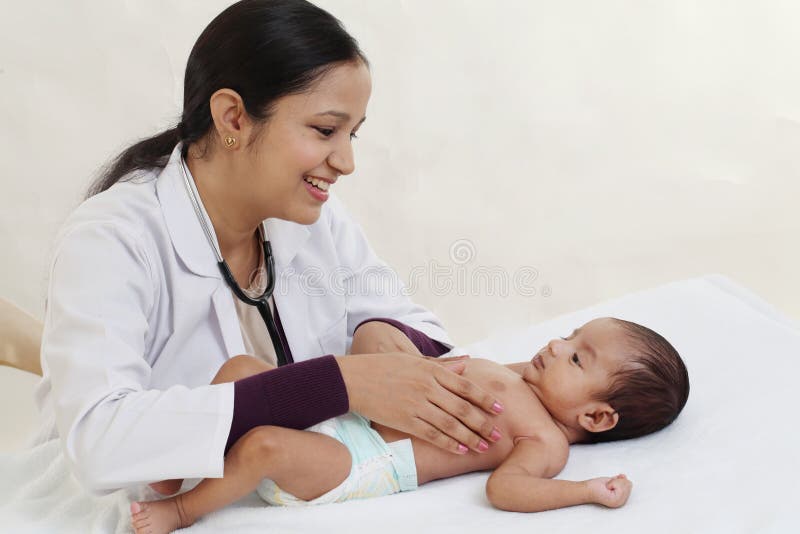 Il pediatra femminile tiene il neonato immagini stock Il pediatra femminile tiene il neonato immagini stock