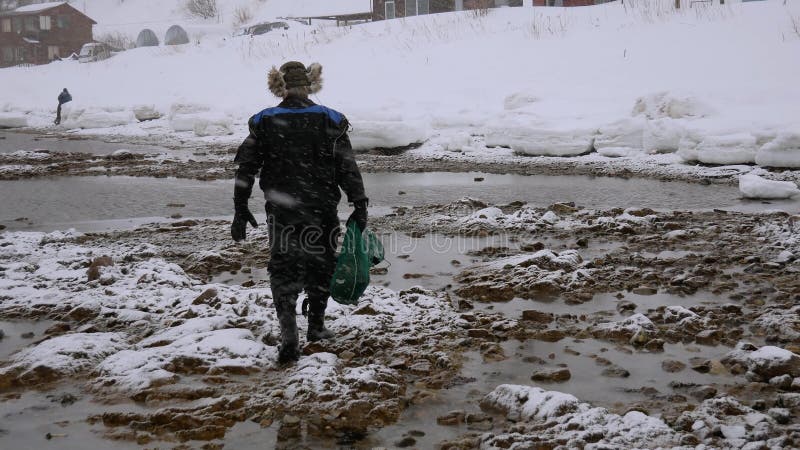 Il pescatore Goes With una griglia completa di frutti di mare è sulla spiaggia nell'inverno video d archivio