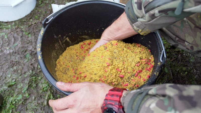 Il pescatore passa l'esca di miscelazione per il pesce Esca di cottura trattata per il pesce Pesca del richiamo stock footage